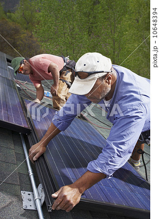 Construction workers installing solar panels on roof Construction workers installing solar panels on roof 10648394
