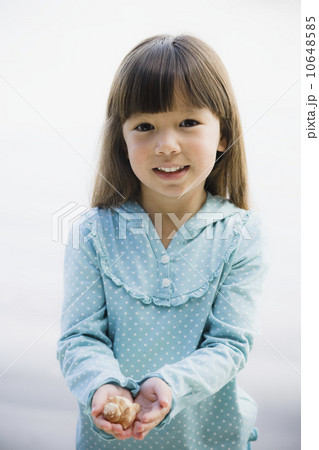 Young girl holding seashell 10648585