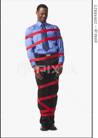 Businessman wrapped in red tape 10648825