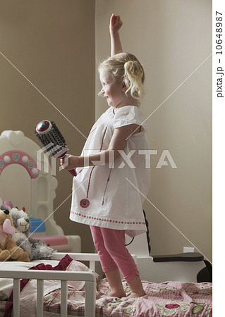 Young girl dancing on her bed Young girl dancing on her bed 10648987