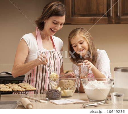 Mother baking with daughter (10-11) in kitchen 10649236