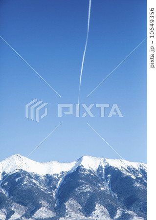 Vapor trail on clear sky above mountains Vapor trail on clear sky above mountains 10649356