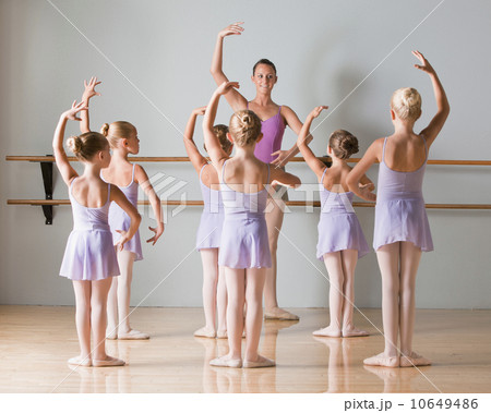 Female instructor training ballet dancers (6-8) in dance studio 10649486