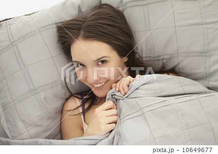 Portrait of young woman lying in bed Portrait of young woman lying in bed 10649677
