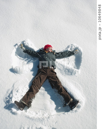 Woman making snow angel Woman making snow angel 10649848