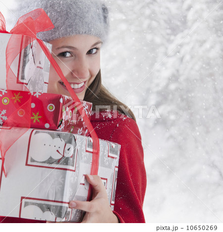 Woman holding stack of Christmas presents 10650269