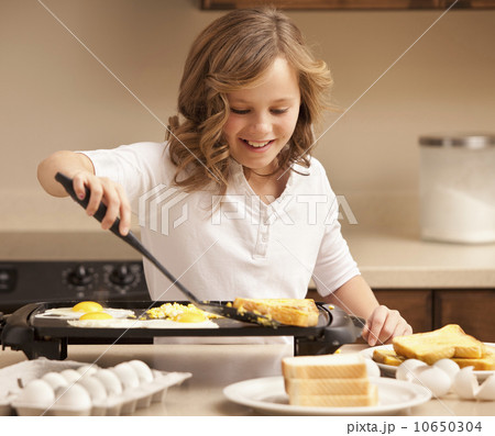 Girl (10-11) preparing breakfast in kitchen 10650304
