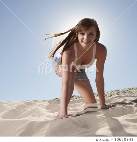 Pretty woman kneeling in sand 10650343