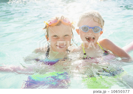 Girlfriends (4-5, 8-9) playing in swimming pool 10650377