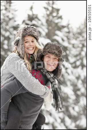 USA, Utah, Salt Lake City, man giving young woman piggy back ride in snow 10650501