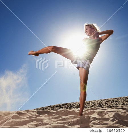 Female dancer kicking her leg on the beach 10650590