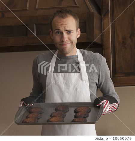 Man holding tray of burnt cookies 10650679
