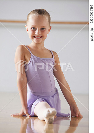 Portrait of ballet dancer (6-7) performing splits in dance studio 10650764