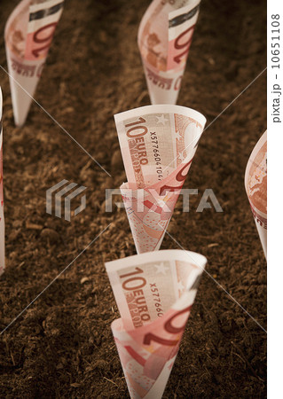 Rolled up ten euro notes stuck in ground 10651108