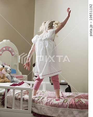 Young girl dancing on her bed Young girl dancing on her bed 10651192