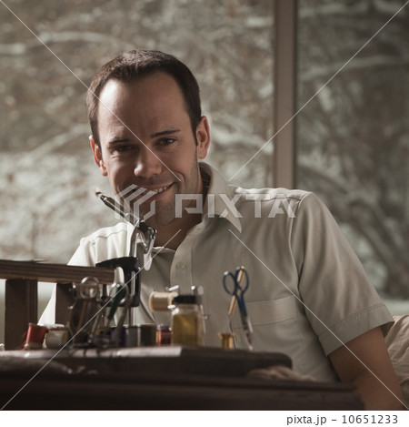 Man sitting behind fishing repair equipment Man sitting behind fishing repair equipment 10651233