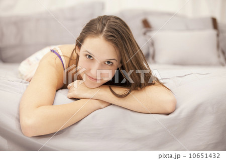 Portrait of young woman relaxing on bed 10651432