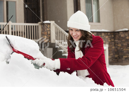 USA, Utah, Lehi, Young woman scraping snow from car 10651504