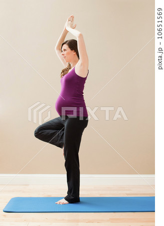 USA, Utah, Lehi, Young pregnant woman exercising, standing on one leg 10651569