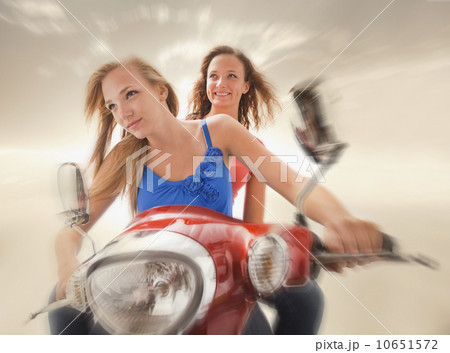 Young girls (16-17) riding scooter 10651572
