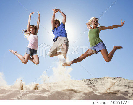 Three people jumping in the sand Three people jumping in the sand 10651722