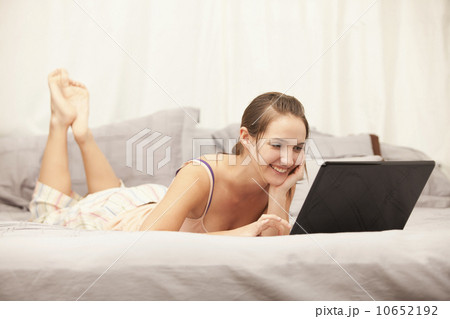 Young woman using laptop on bed Young woman using laptop on bed 10652192