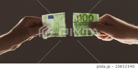 Hands holding torn one hundred euro note 10652340