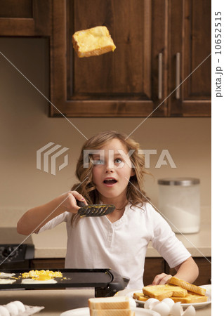 Girl (10-11) flipping toast in kitchen Girl (10-11) flipping toast in kitchen 10652515