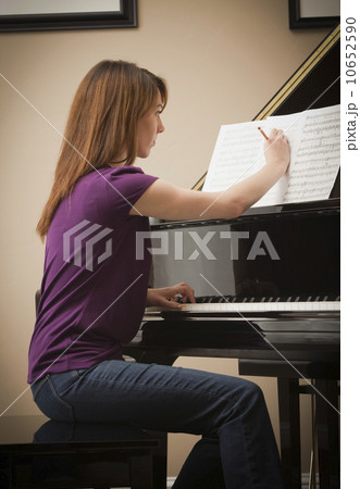 USA, Utah, Lehi, Young woman marking score before setting to play grand piano 10652590