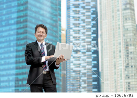 Successful entrepreneur business man using laptop in front of office building 10656793