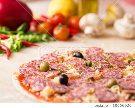 raw salami italian pizza with capers 10656926