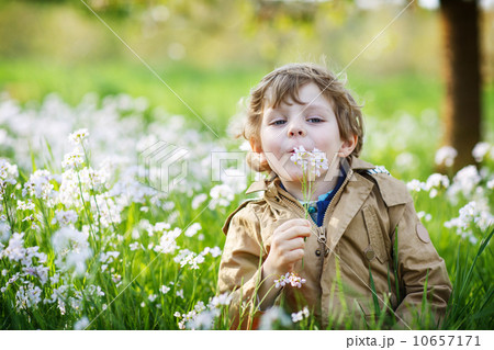 Happy little  boy in spring garden with blooming white flowers 10657171