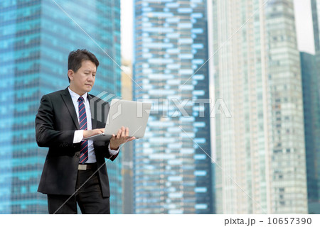Successful entrepreneur business man using mobile device laptop in front of glass office building Successful entrepreneur business man using mobile device laptop in front of glass office building 10657390