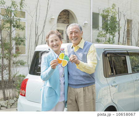 高齢運転者標識を持って立つシニア夫婦 10658067