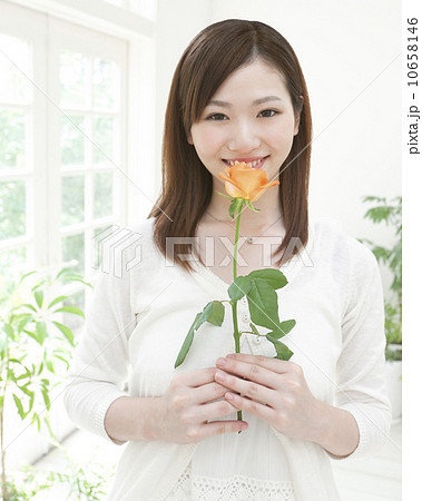 一輪の花を持つ女性の写真素材