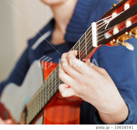 woman plays on modern acoustic guitar 10658591