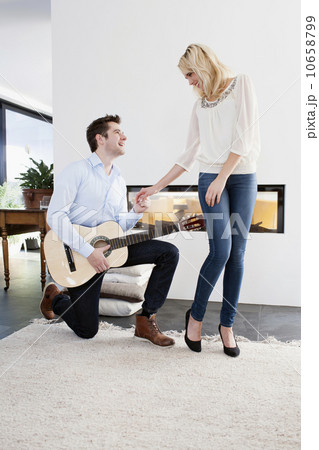 Man playing guitar in front of woman Man playing guitar in front of woman 10658799
