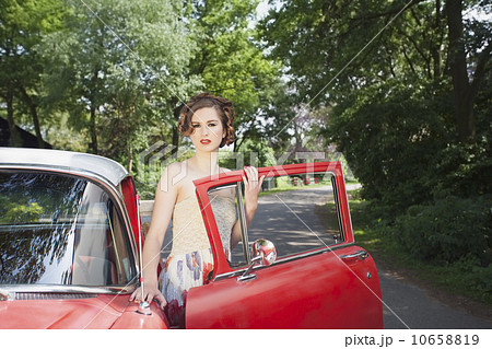 Portrait of elegant woman next to vintage car 10658819