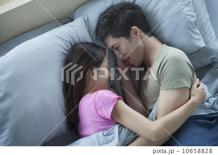 Elevated view of man and woman embracing in bed 10658828