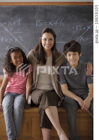 Portrait of teacher in classroom with schoolboy (10-11) and schoolgirl (12-13) Portrait of teacher in classroom with schoolboy (10-11) and schoolgirl (12-13) 10659105