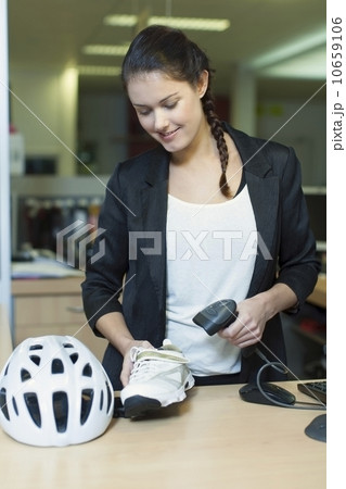 Sales clerk selling cycling shoes and helmet Sales clerk selling cycling shoes and helmet 10659106