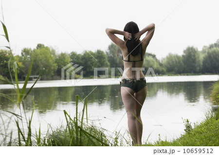 France, Picardie, Albert, Young woman in bikini standing on lake shore 10659512