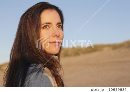 Portrait of woman standing against sand dune Portrait of woman standing against sand dune 10659685