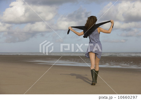 France, Pas-de-Calais, Escalles, Young woman strolling on empty beach 10660297