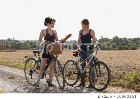France, Picardie, Albert, Young women on bikes on country road France, Picardie, Albert, Young women on bikes on country road 10660361