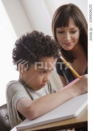 Pupil writing together with teacher Pupil writing together with teacher 10660620