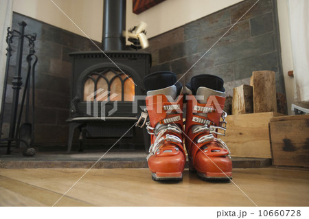 Ski boots drying in front of fireplace 10660728