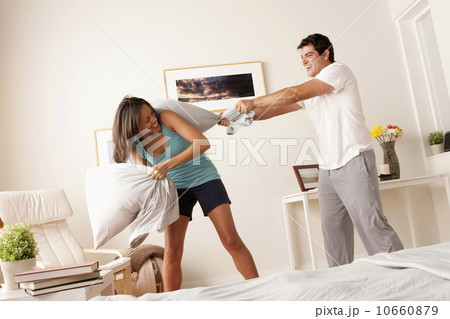 Couple fighting with pillow in bedroom 10660879