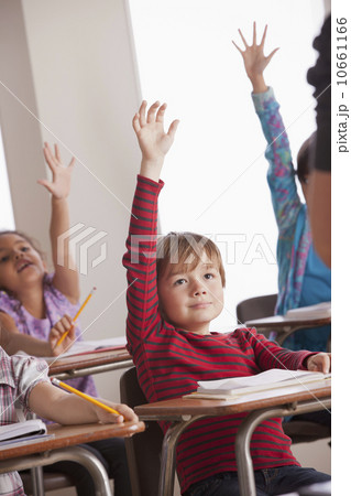 Pupils in classroom raising hands Pupils in classroom raising hands 10661166