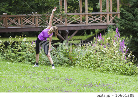 Young woman stretching her upper body in field Young woman stretching her upper body in field 10661289